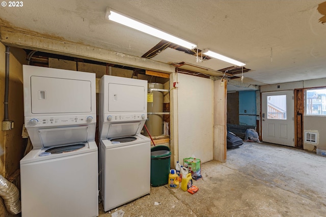 clothes washing area featuring stacked washing maching and dryer