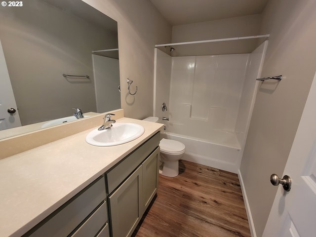 full bathroom with shower / washtub combination, vanity, toilet, and hardwood / wood-style flooring