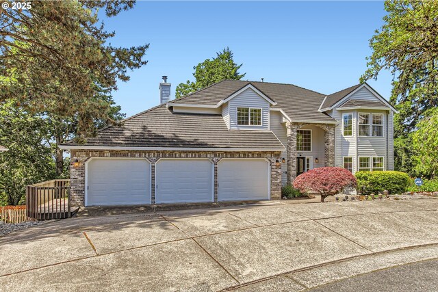 16675 SW Heceta Ct, Beaverton, OR 97007 - traditional-style house featuring concrete driveway, a garage, a chimney, and brick siding