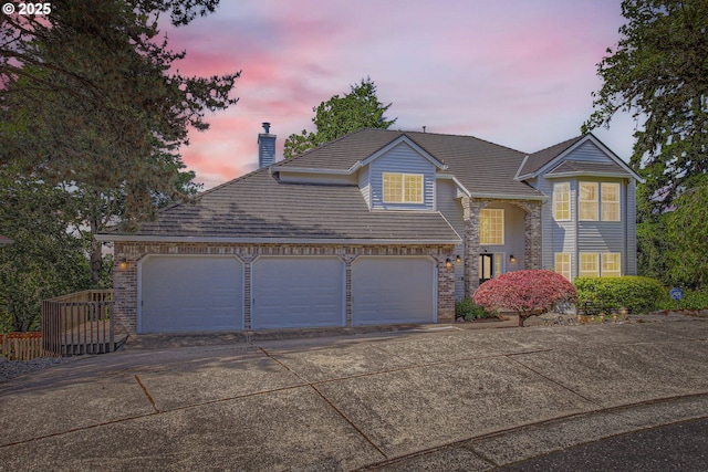 16675 SW Heceta Ct, Beaverton, OR 97007 - traditional-style home featuring driveway, a garage, and a chimney