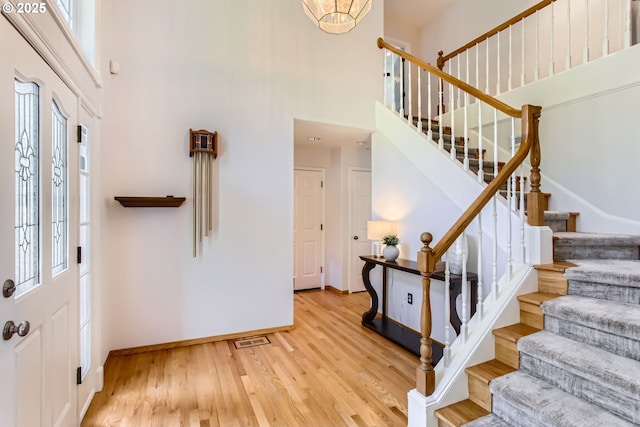 16675 SW Heceta Ct, Beaverton, OR 97007 - entrance foyer featuring a high ceiling, healthy amount of natural light, baseboards, stairway, and wood finished floors