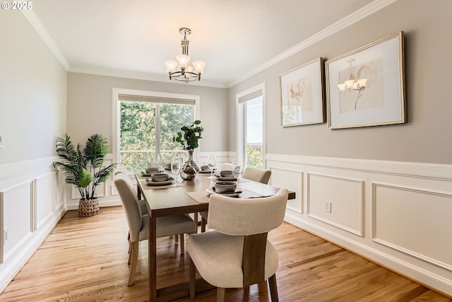 16675 SW Heceta Ct, Beaverton, OR 97007 - dining room featuring a decorative wall, a chandelier, light wood-style floors, ornamental molding, and wainscoting