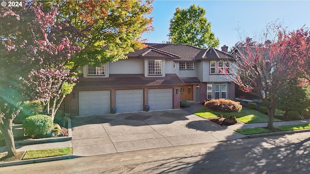 view of front of property featuring driveway, an attached garage, a chimney, and brick siding