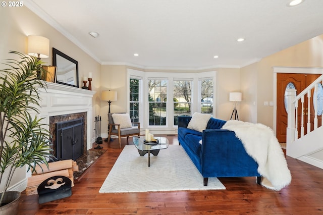 living room featuring a premium fireplace, crown molding, and dark hardwood / wood-style flooring