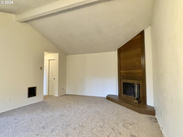 unfurnished living room with carpet flooring, vaulted ceiling with beams, and a large fireplace