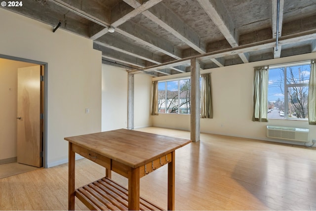 basement featuring light hardwood / wood-style floors and an AC wall unit