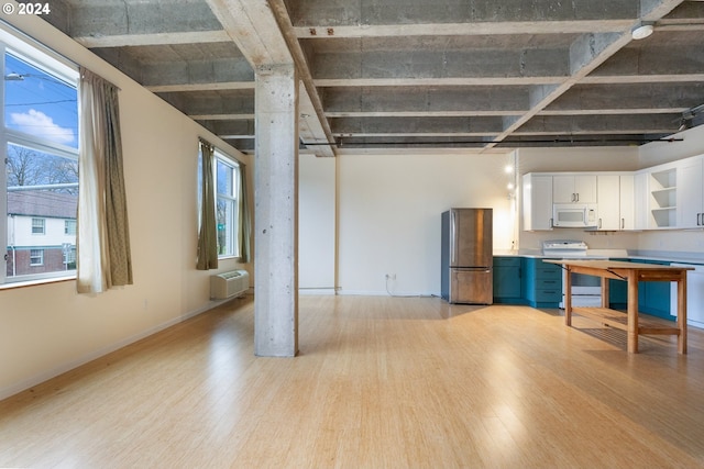 kitchen featuring white cabinetry, a wall mounted air conditioner, white appliances, and light wood-type flooring