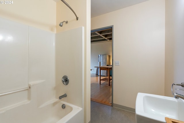 bathroom with sink, hardwood / wood-style floors, and washtub / shower combination