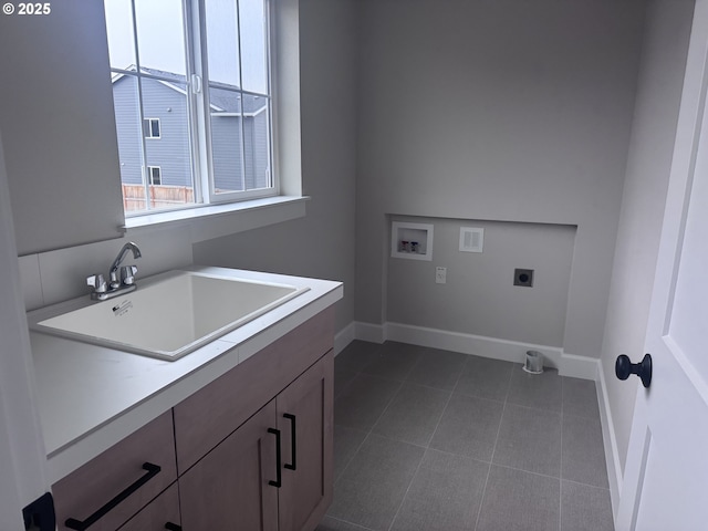 laundry room featuring sink, hookup for a washing machine, cabinets, hookup for an electric dryer, and dark tile patterned flooring