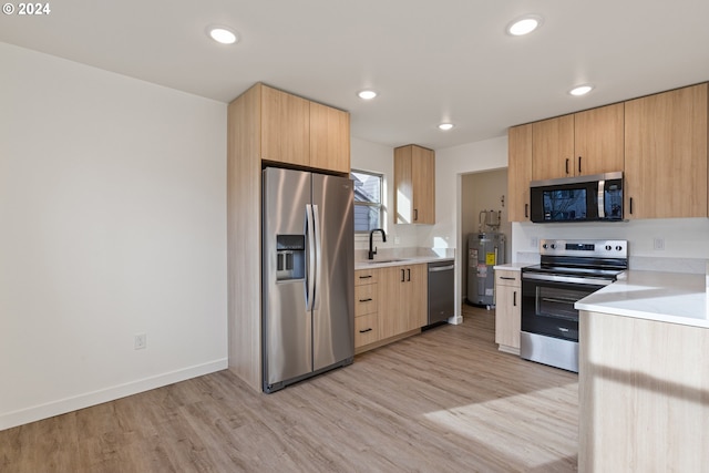 kitchen with light hardwood / wood-style floors, light brown cabinetry, sink, and appliances with stainless steel finishes