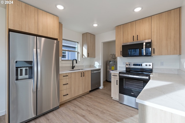 kitchen featuring sink, light wood-type flooring, light brown cabinetry, water heater, and stainless steel appliances