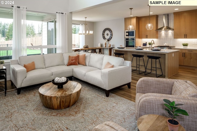 living room with light wood-type flooring and a chandelier