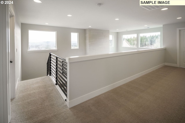 hall with light colored carpet