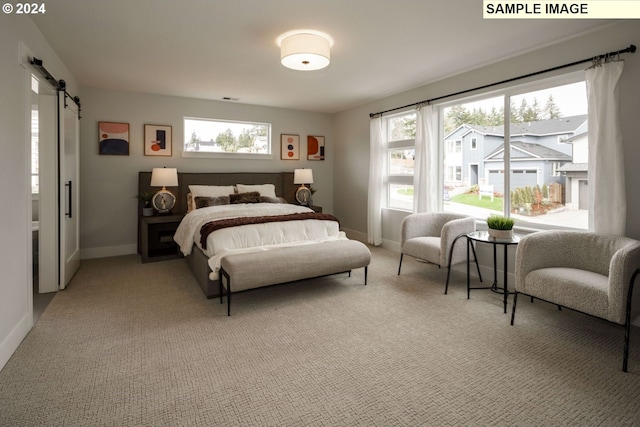 bedroom with a barn door and light carpet