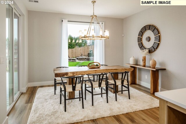 dining area featuring an inviting chandelier and light wood-type flooring