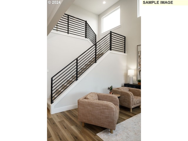 stairs with dark hardwood / wood-style flooring and a towering ceiling