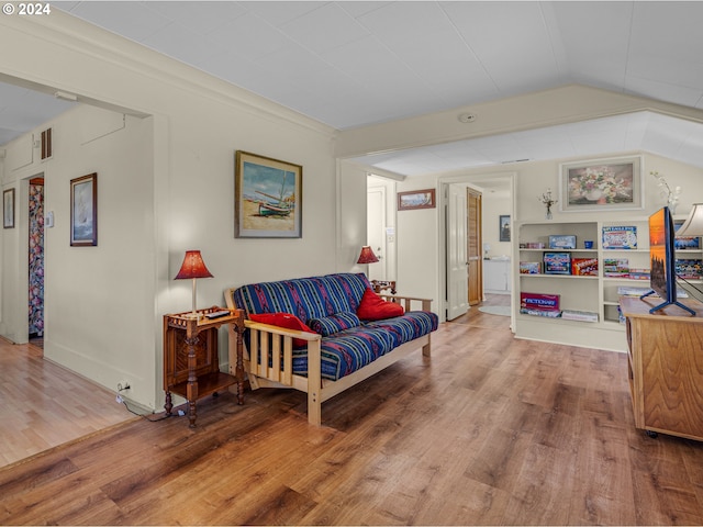 living room featuring wood-type flooring and vaulted ceiling