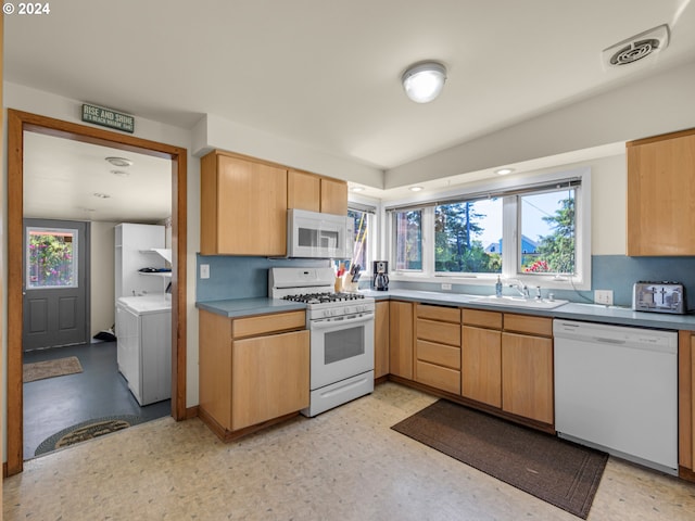 kitchen featuring washer / clothes dryer, sink, white appliances, and light brown cabinets