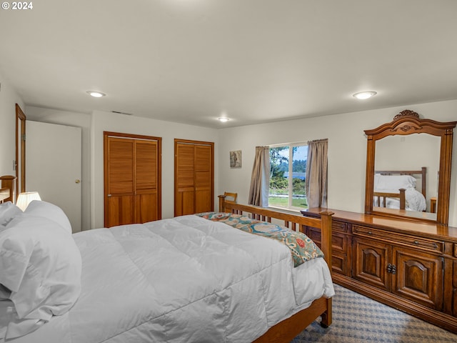 carpeted bedroom featuring two closets