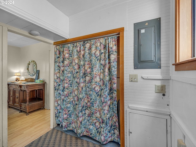 bathroom featuring electric panel and hardwood / wood-style flooring