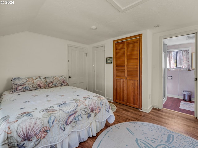 bedroom with hardwood / wood-style flooring, a closet, and vaulted ceiling