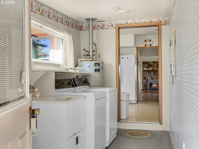 laundry room with water heater, a fireplace, and washer and dryer