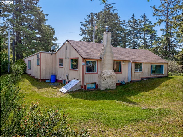 rear view of property featuring a lawn