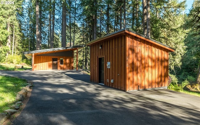 exterior space with wooden walls and a carport