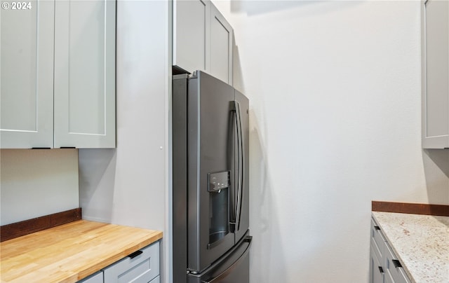 kitchen featuring stainless steel fridge and butcher block counters