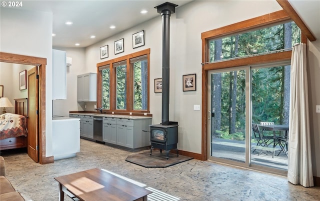 interior space with a wood stove, a wealth of natural light, and sink