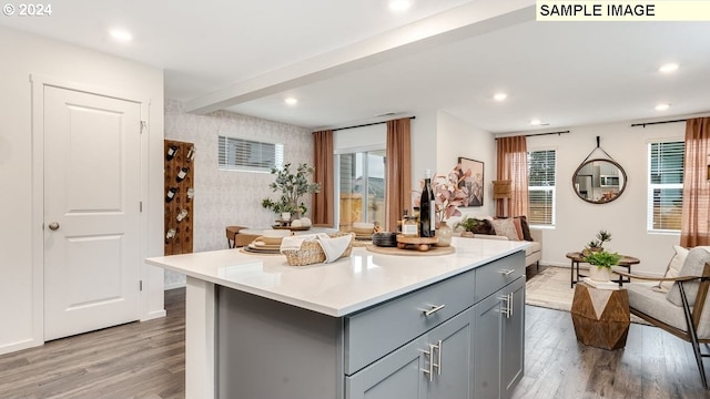 kitchen featuring gray cabinets, a kitchen island, and light hardwood / wood-style flooring