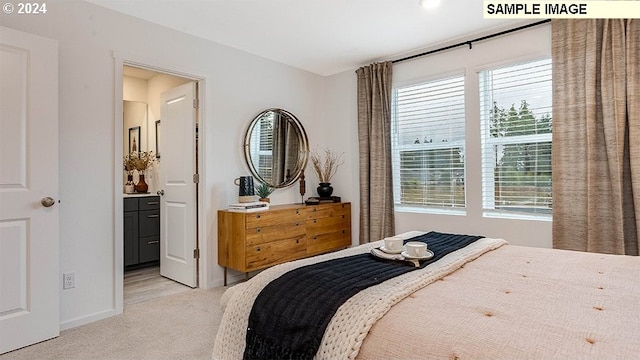 bedroom with ensuite bath and light carpet