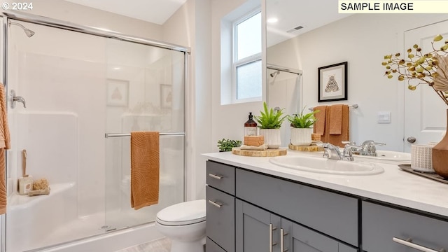 bathroom featuring vanity, toilet, and walk in shower