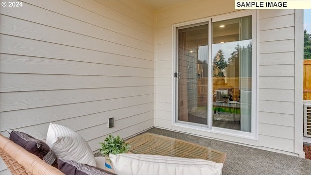 view of exterior entry with a patio area and an outdoor hangout area