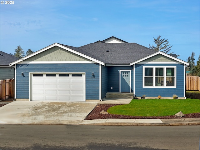 view of front of home with an attached garage, concrete driveway, a front lawn, and fence