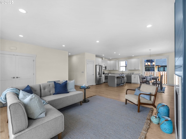 living area featuring recessed lighting, light wood-style floors, and baseboards