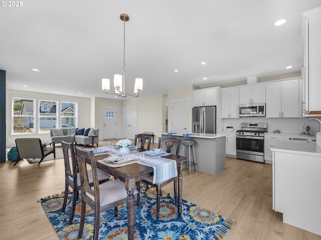 dining area featuring light wood-type flooring, an inviting chandelier, and recessed lighting