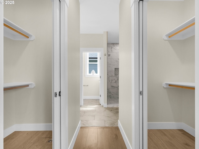 full bath with a shower stall, marble finish floor, and baseboards