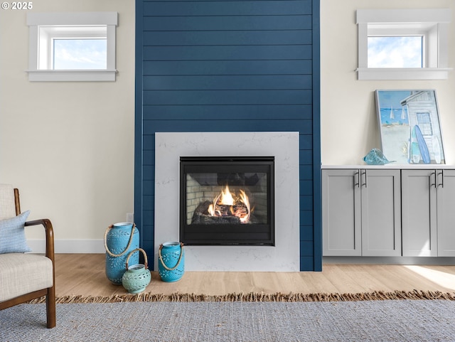 room details with a high end fireplace, wood finished floors, and baseboards
