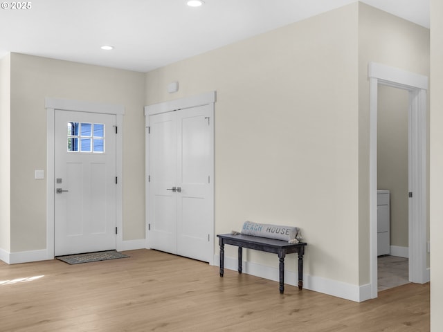 entrance foyer featuring baseboards, wood finished floors, recessed lighting, and washer / dryer
