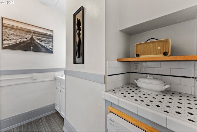 bathroom with vanity, baseboards, and backsplash