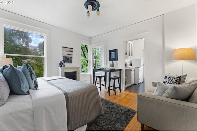 bedroom featuring fridge and hardwood / wood-style flooring