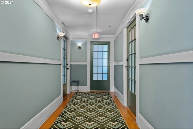 doorway featuring wood finished floors and baseboards