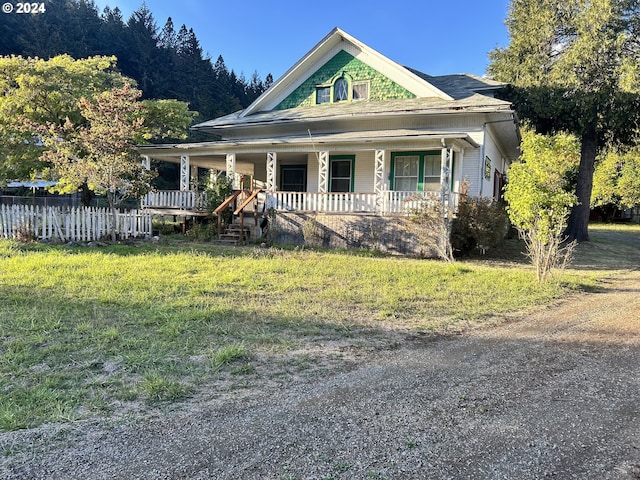 view of front of home with covered porch and a front lawn