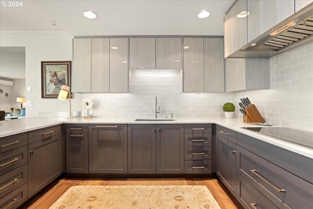 kitchen featuring ventilation hood, gray cabinets, sink, tasteful backsplash, and light hardwood / wood-style floors