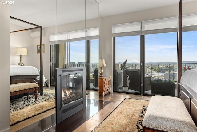 bedroom with an AC wall unit and hardwood / wood-style flooring