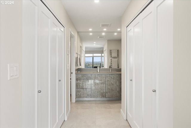 corridor with light tile patterned floors and sink