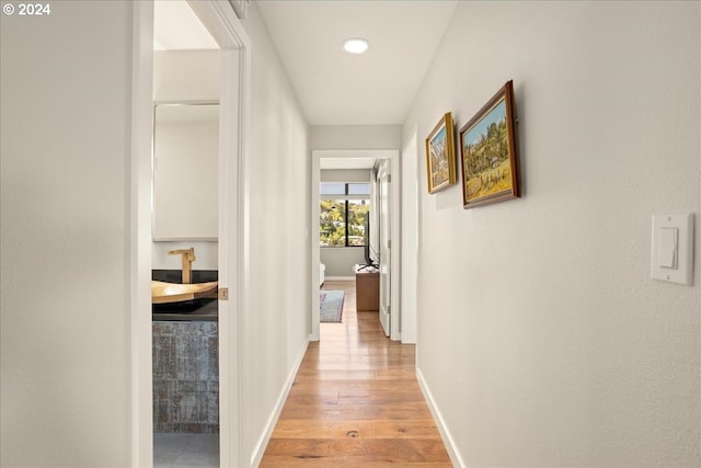 hallway with light hardwood / wood-style floors