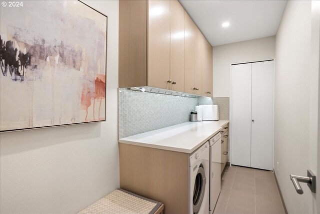 laundry room featuring light tile patterned flooring, washer / clothes dryer, and cabinets