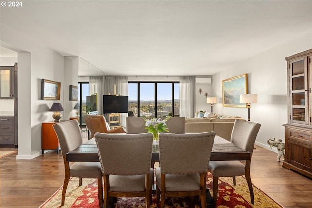 dining space featuring an AC wall unit and hardwood / wood-style flooring